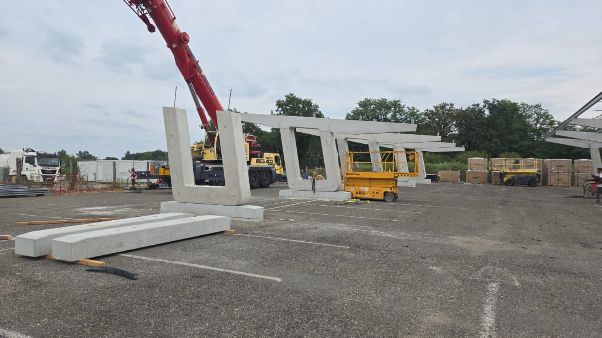 Grutage d'ombrière photovoltaïque en béton et structure métallique en construction